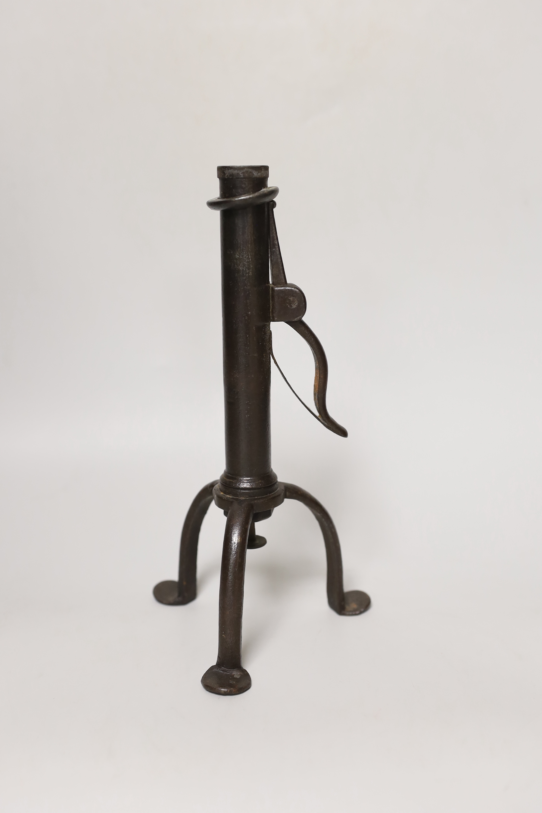 An 18th century rare iron candle holder, English, on tripod base, the cylindrical stem with push ejector with side spring rushlight nip, 22.5cm tall